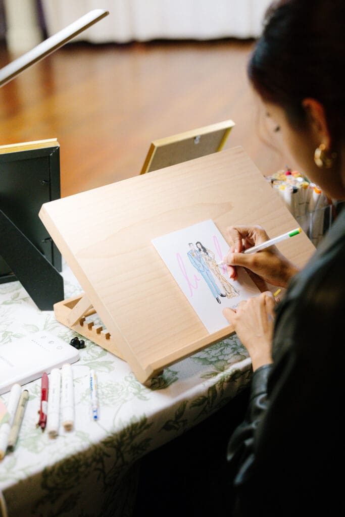 Live wedding artist creating custom guest illustrations at a wedding reception in Brenham, Texas.