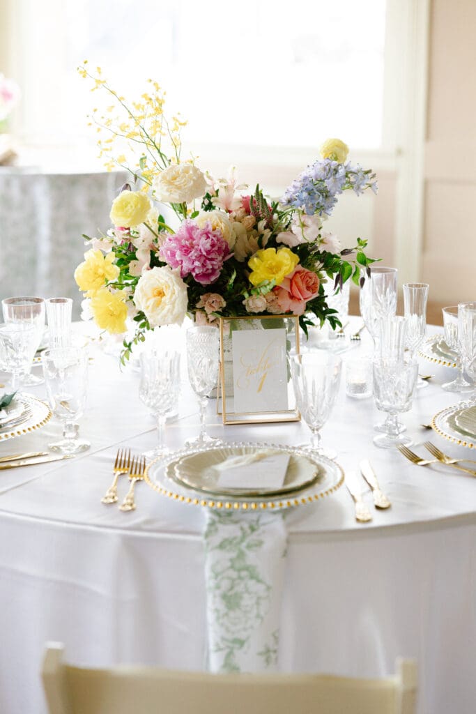 Garden-inspired wedding reception table with pastel floral centerpiece, vintage-inspired place settings, and elegant details at Ant Street Inn wedding in Brenham, Texas.